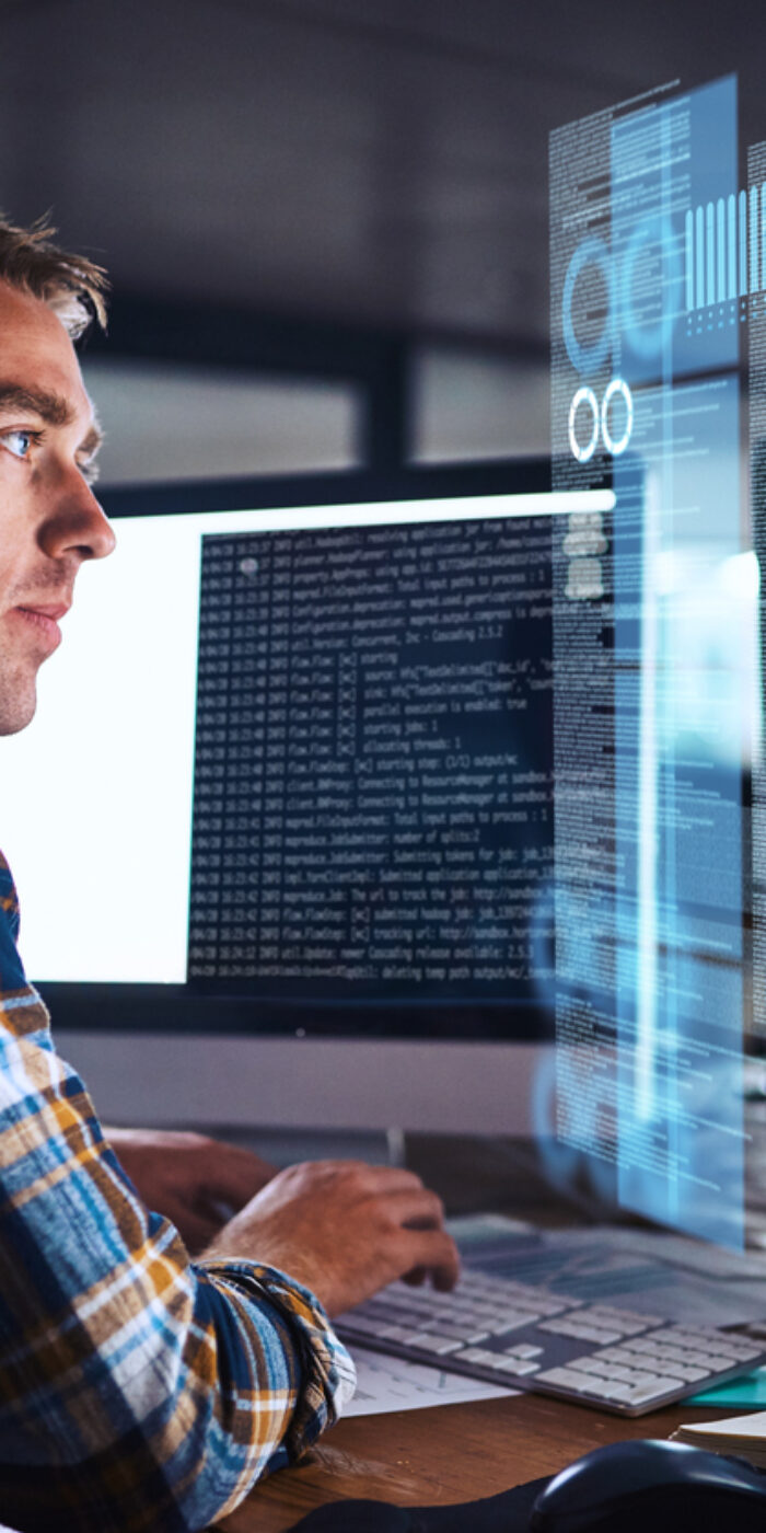 Shot of a young programmer working at his computer with an overlay of computer graphics