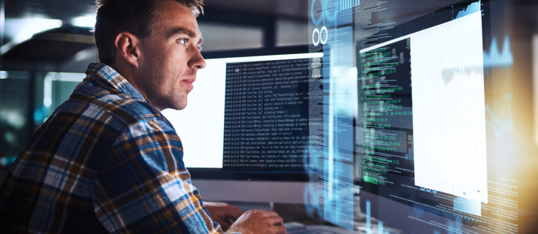 Shot of a young programmer working at his computer with an overlay of computer graphics